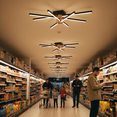 Uzun koridorlu bir markette tavana monte edilmiş Nova Eight led aydınlatma sistemleri.