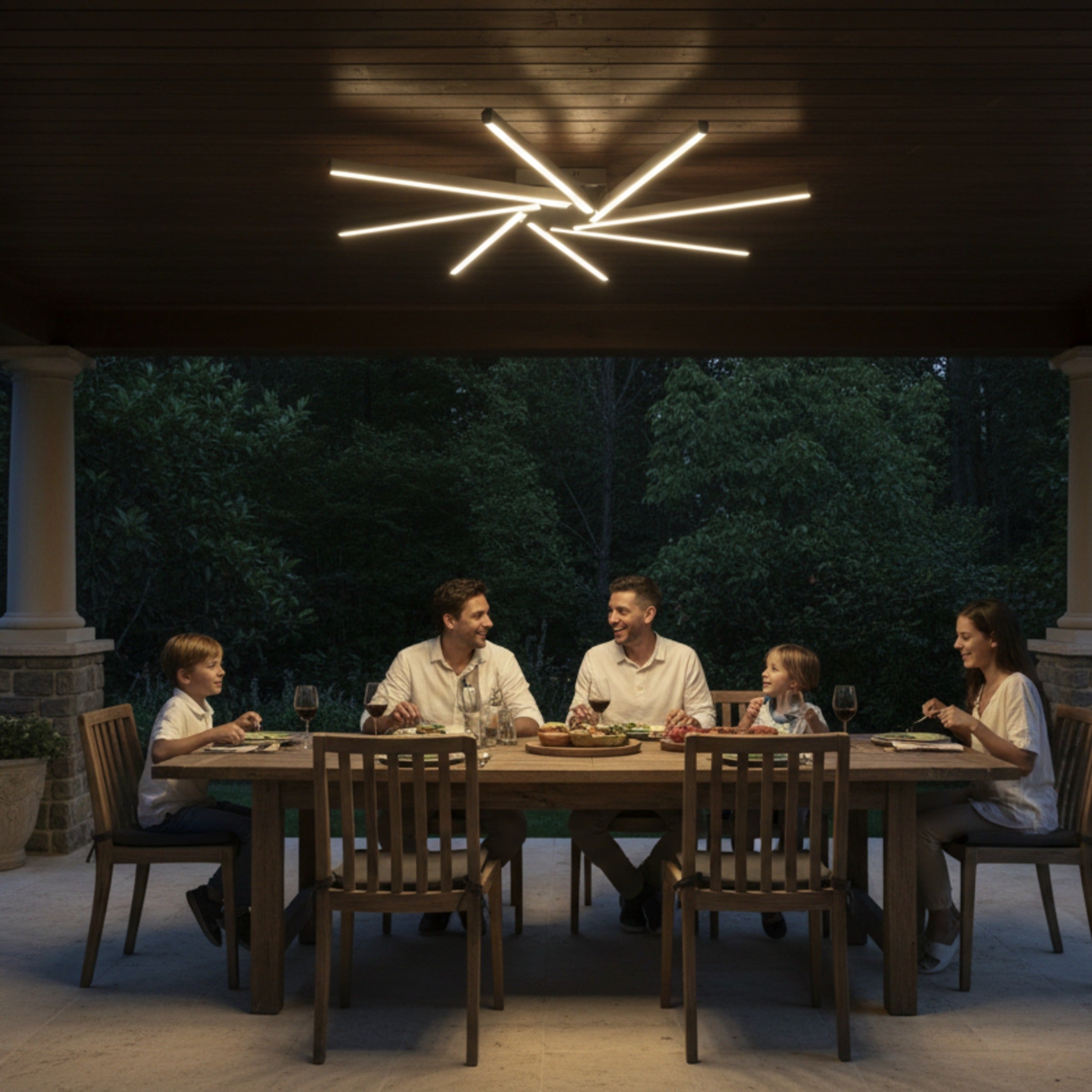 Pergole altı yemek masasında Zenit modern LED avize ile aydınlatılan sıcak bir aile akşamı.