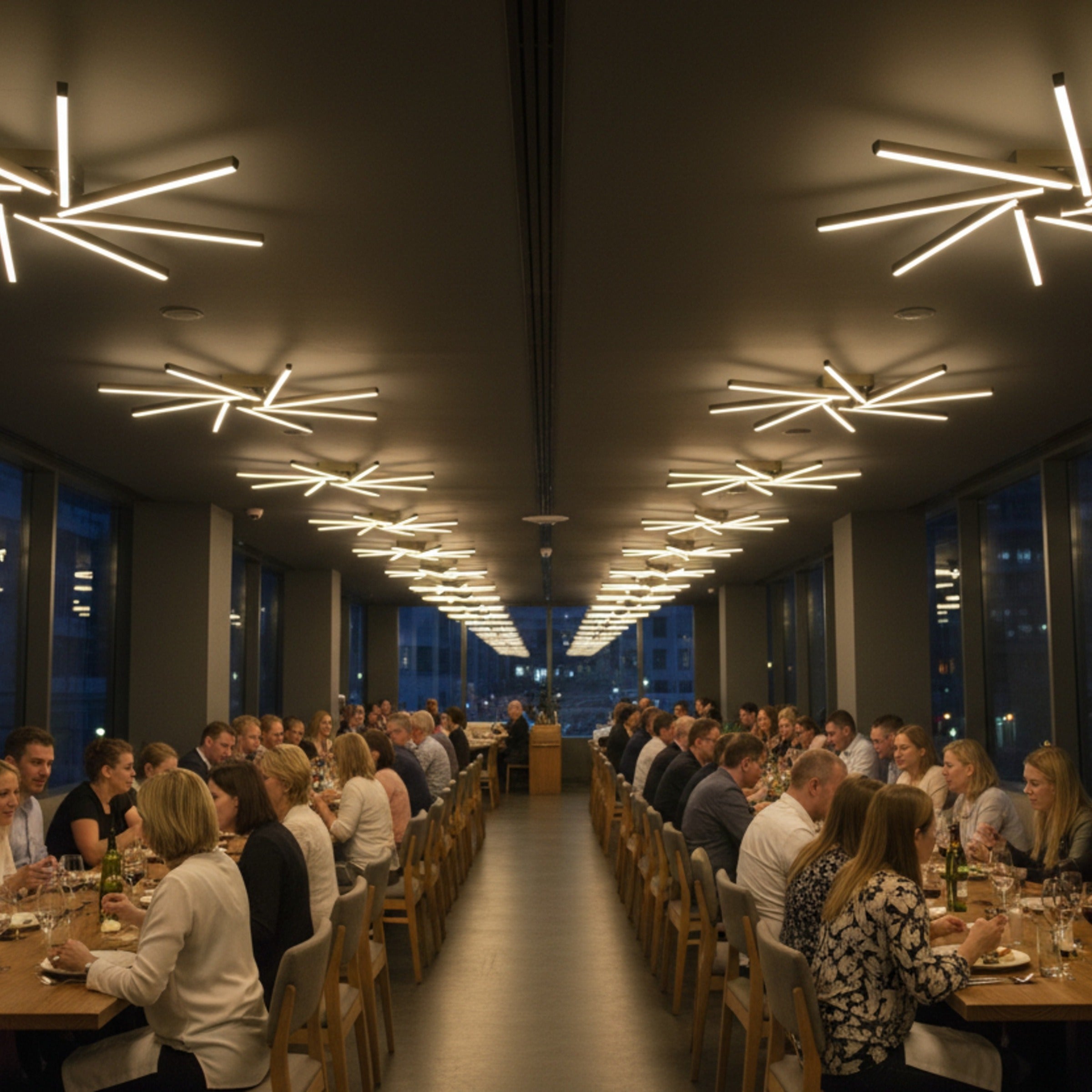 Zenit modern LED avize ile kalabalık restoran masasında loş aydınlatma.