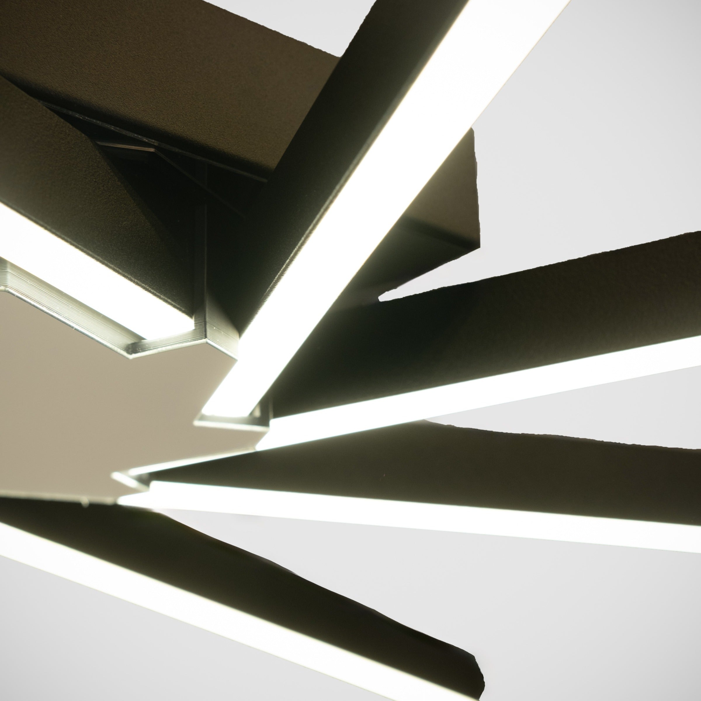 Siyah modern avizenin gövde ve lineer kol birleşimindeki lüks metalik doku detayı