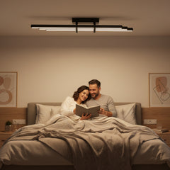 Yatak odasında kitap okuyan çiftin üzerinde parlayan siyah Cosmo Downlight Plafonyer aydınlatma.