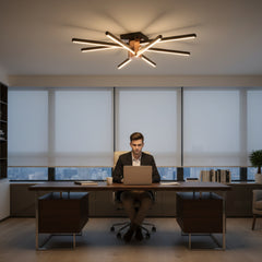 Modern çalışma odasında masasında bilgisayarla çalışan beyefendi ve tavanı süsleyen Nova Eight 8 kollu tavan lambası.