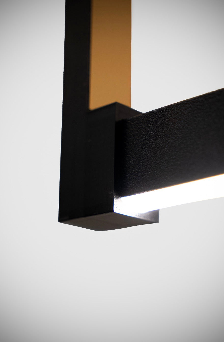 Dim edilebilir Orion modern sarkıtın ışık yayan LED şeridi ve siyah metal gövdesinin köşe birleşim ayrıntısı.