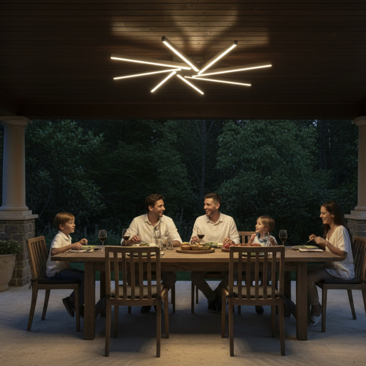 Pergole altı yemek masasında Zenit modern LED avize ile aydınlatılan sıcak bir aile akşamı.