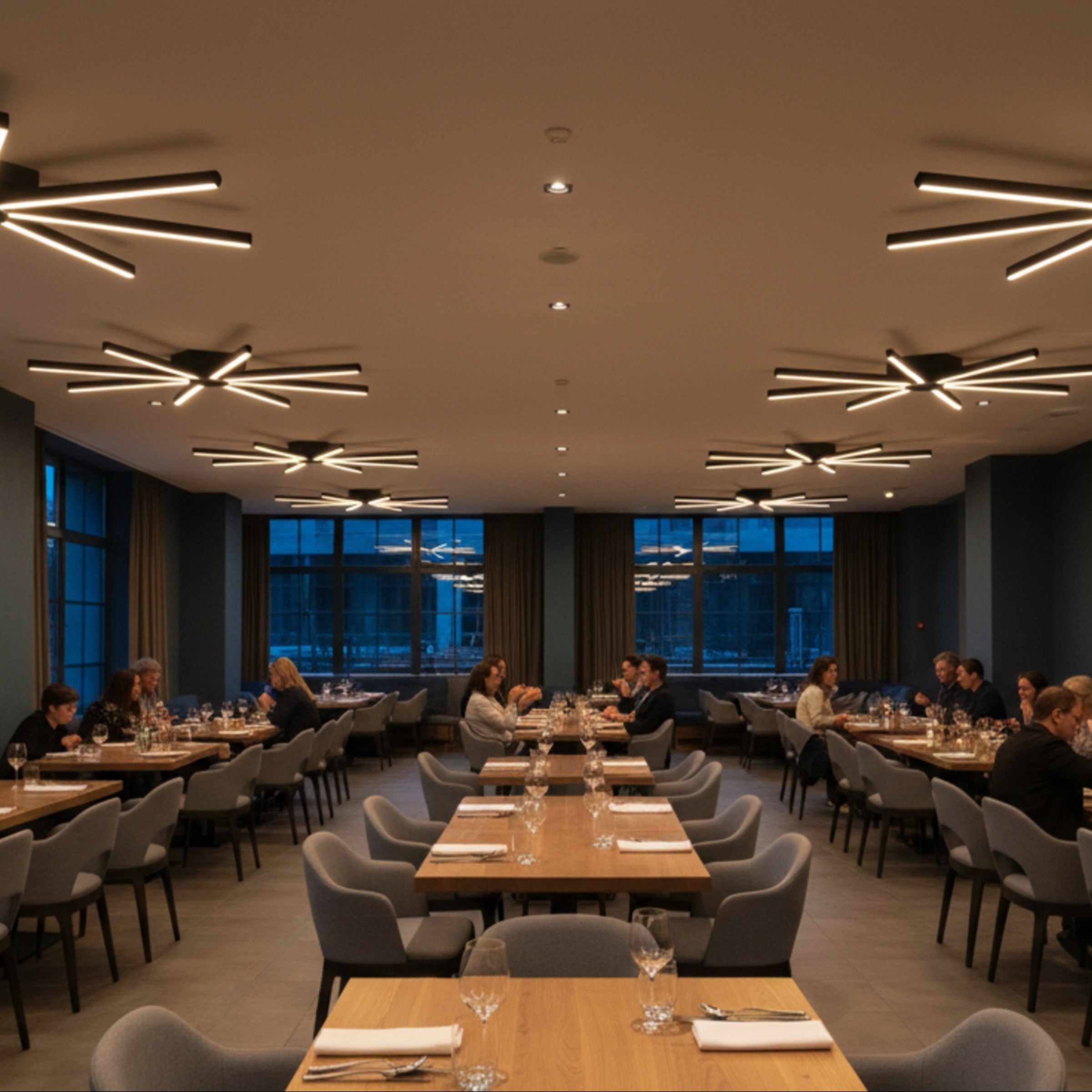 Fine dining restoran dekorasyonunda masaları aydınlatan Pulsar modern LED tavan ışığı.