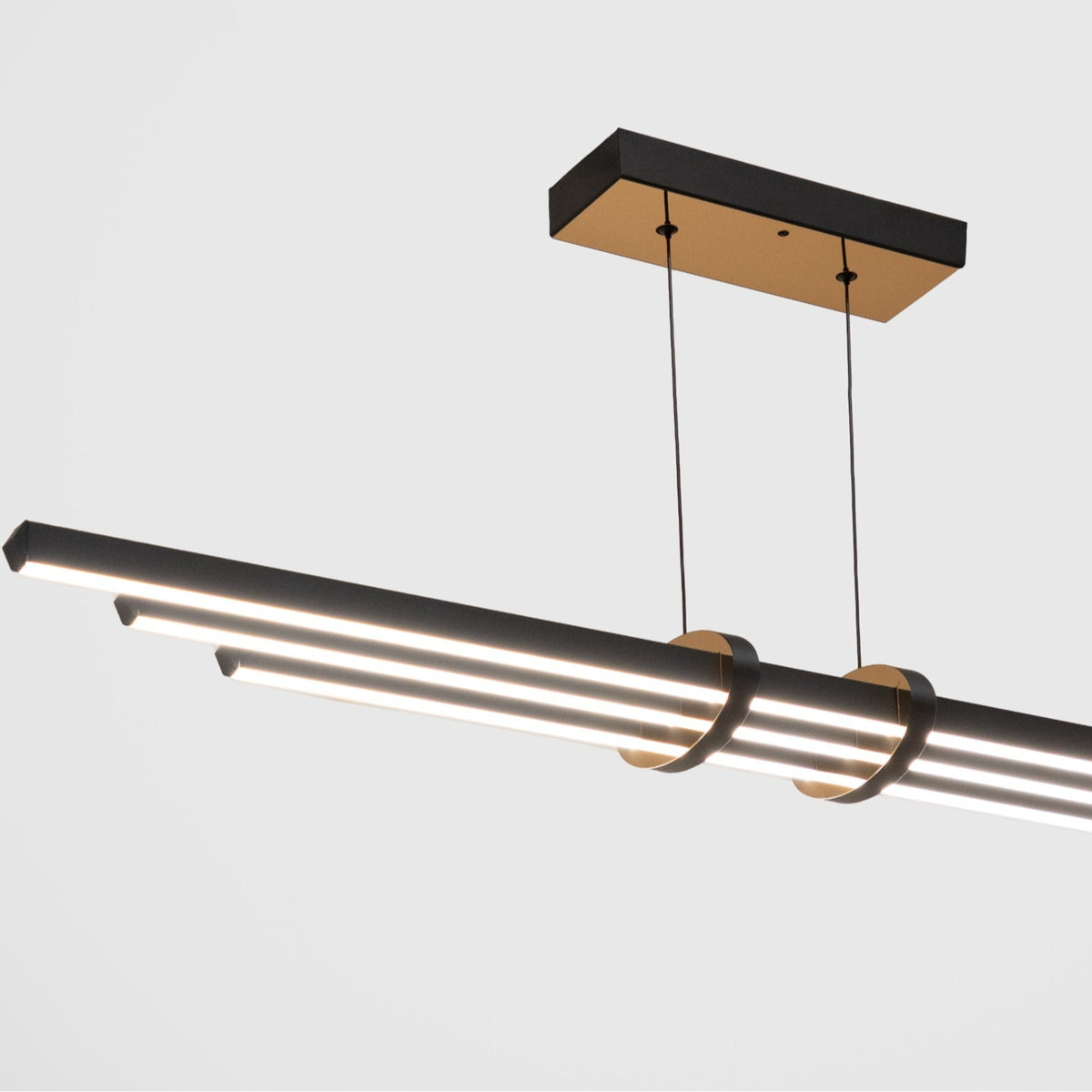 Cosmo serisi siyah gövde ve gold halka detaylı modern lineer sarkıt avizenin yakından lüks görünümü.